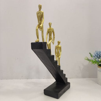 Abstract sculpture of 3 men climbing staircasae