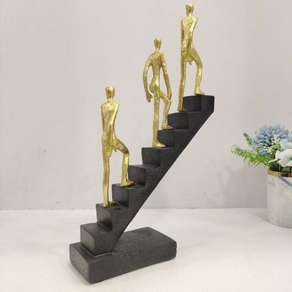 Abstract sculpture of 3 men climbing staircasae