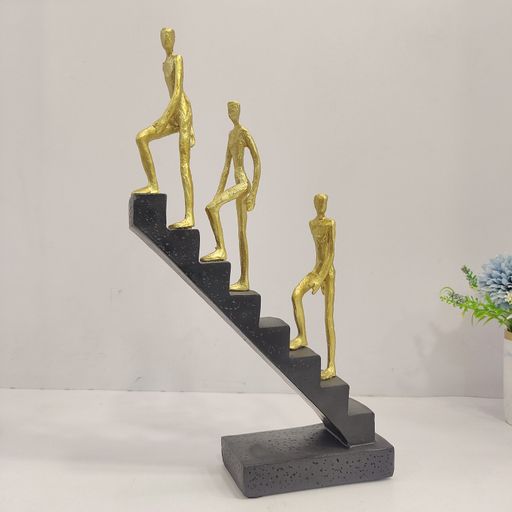 Abstract sculpture of 3 men climbing staircasae